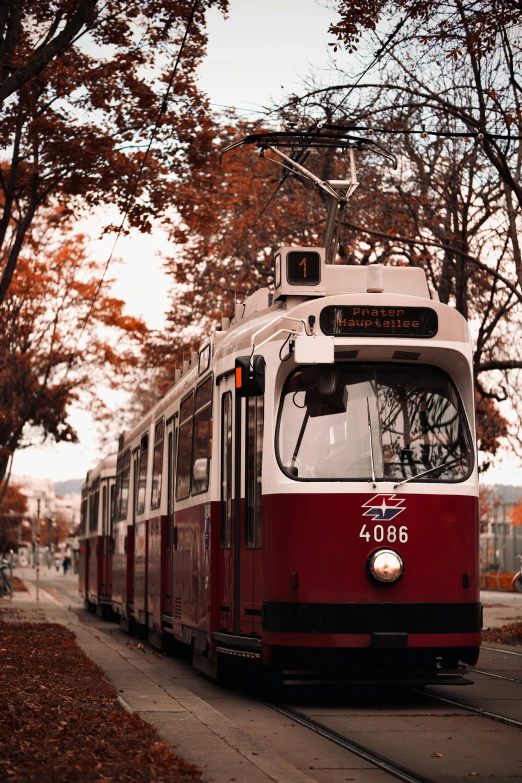 a red and white trolley car with a sign on it