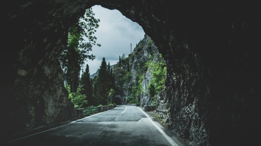 a tunnel is on the road through a mountain side