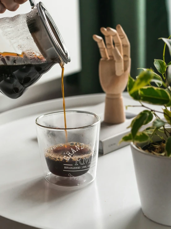 someone pours soing from a pot into a glass