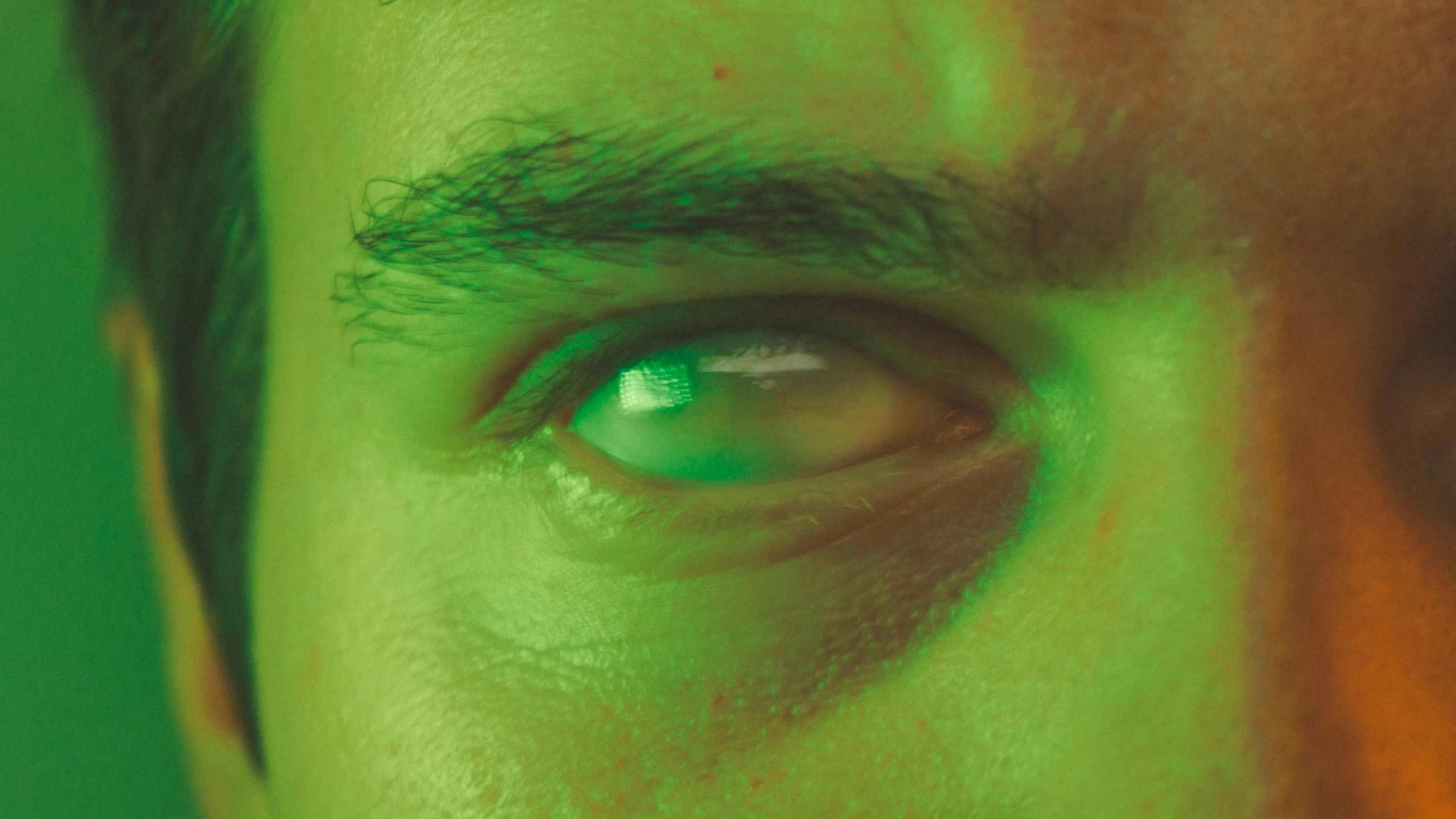 a man's eye is glowing green with white patches