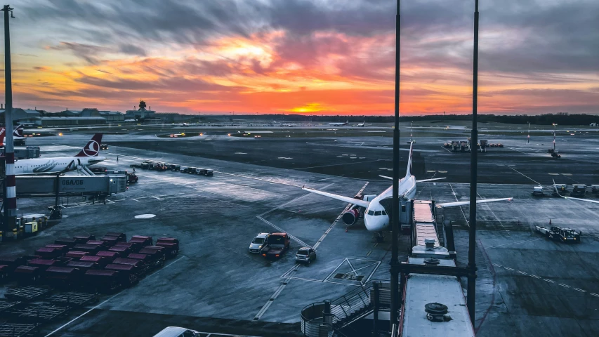 an airport parking lot and terminal with planes in the background