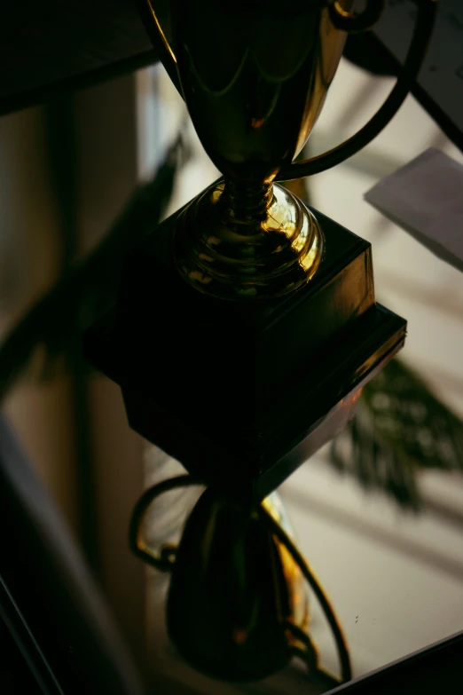 an ornate trophy sitting on top of a glass desk