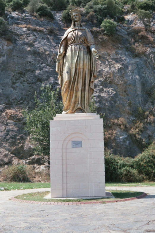 a statue sits on a pedestal with a brown robe on top