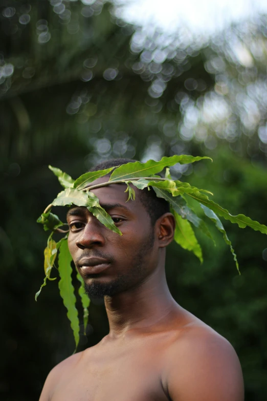 a man wearing a leaf covered headdress posing for a po