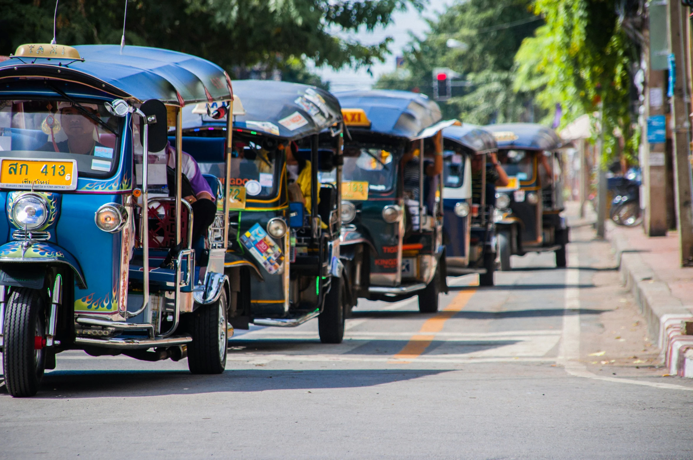 a line of small cars riding down the street