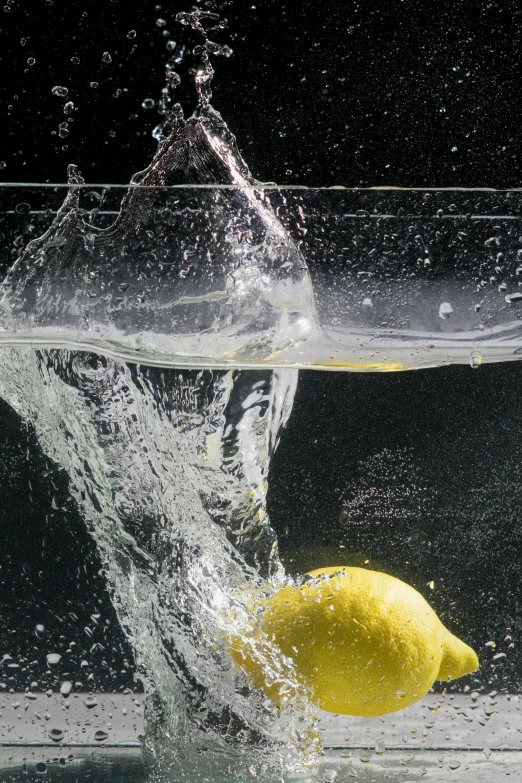 a lemon falling in the water from a bowl