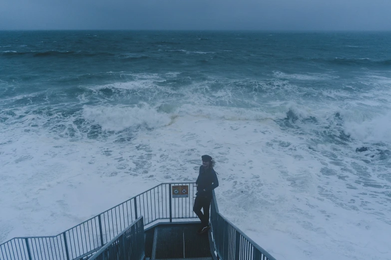 the person is standing on the top of a railing