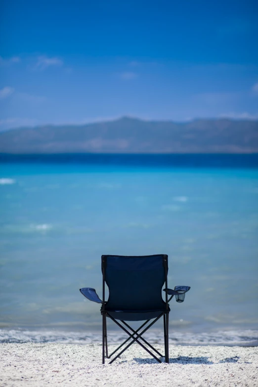 an empty beach chair on a blue sky day