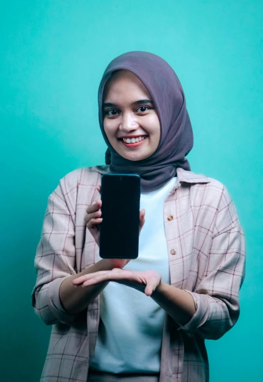 a beautiful young woman holding a cell phone