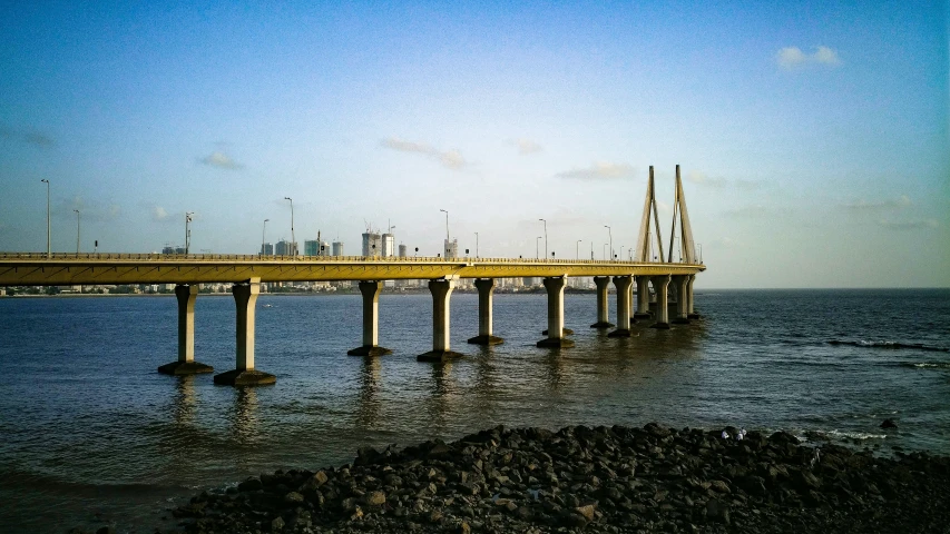 an empty bridge across the water with some rocks