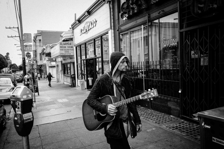 a man playing an acoustic guitar in a black and white po