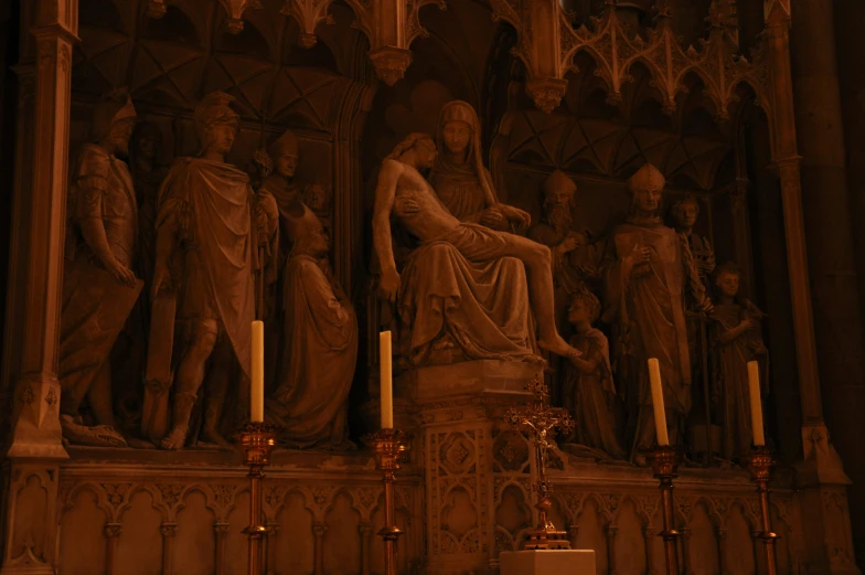 a statue in front of some columns and candles