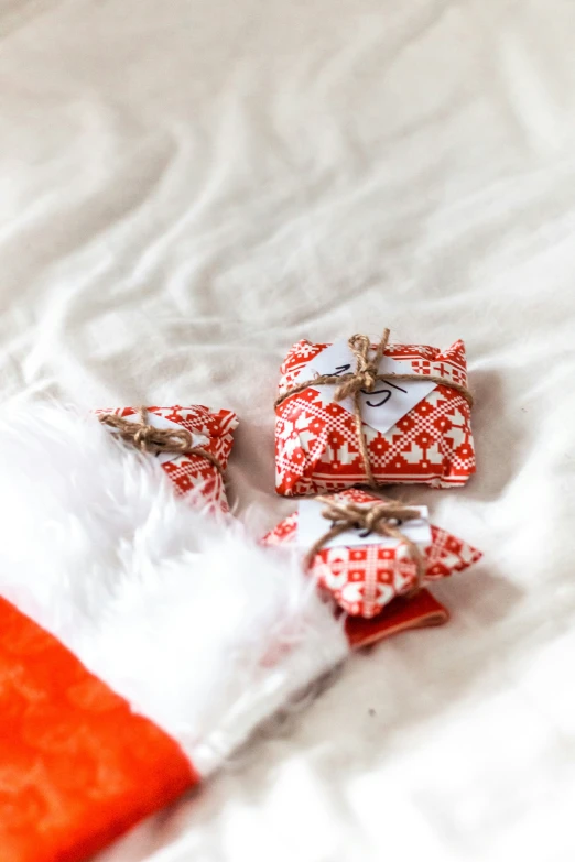 red wrapped gift boxes on a white bed