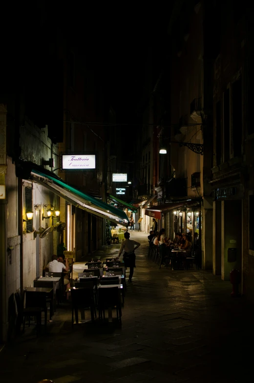 a man sits at an outdoor dining table and drinks