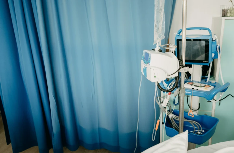 a hospital room with some medical equipment hanging from a curtain