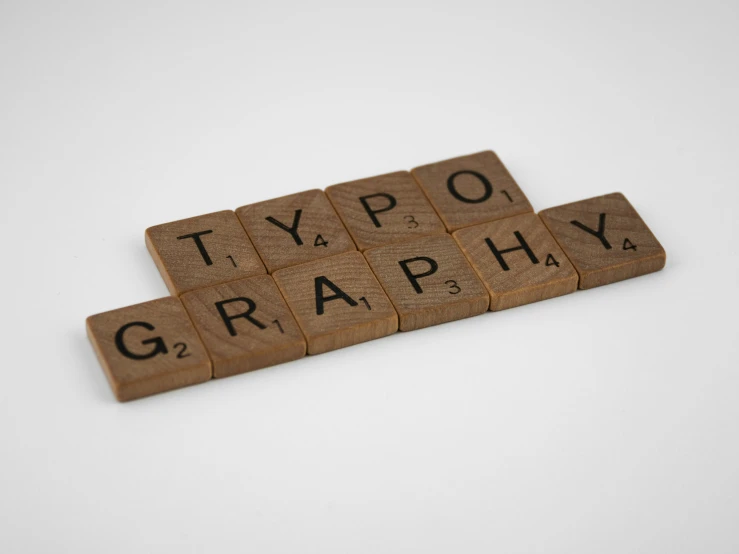 a set of four pieces of scrabble that says typo, graph, and