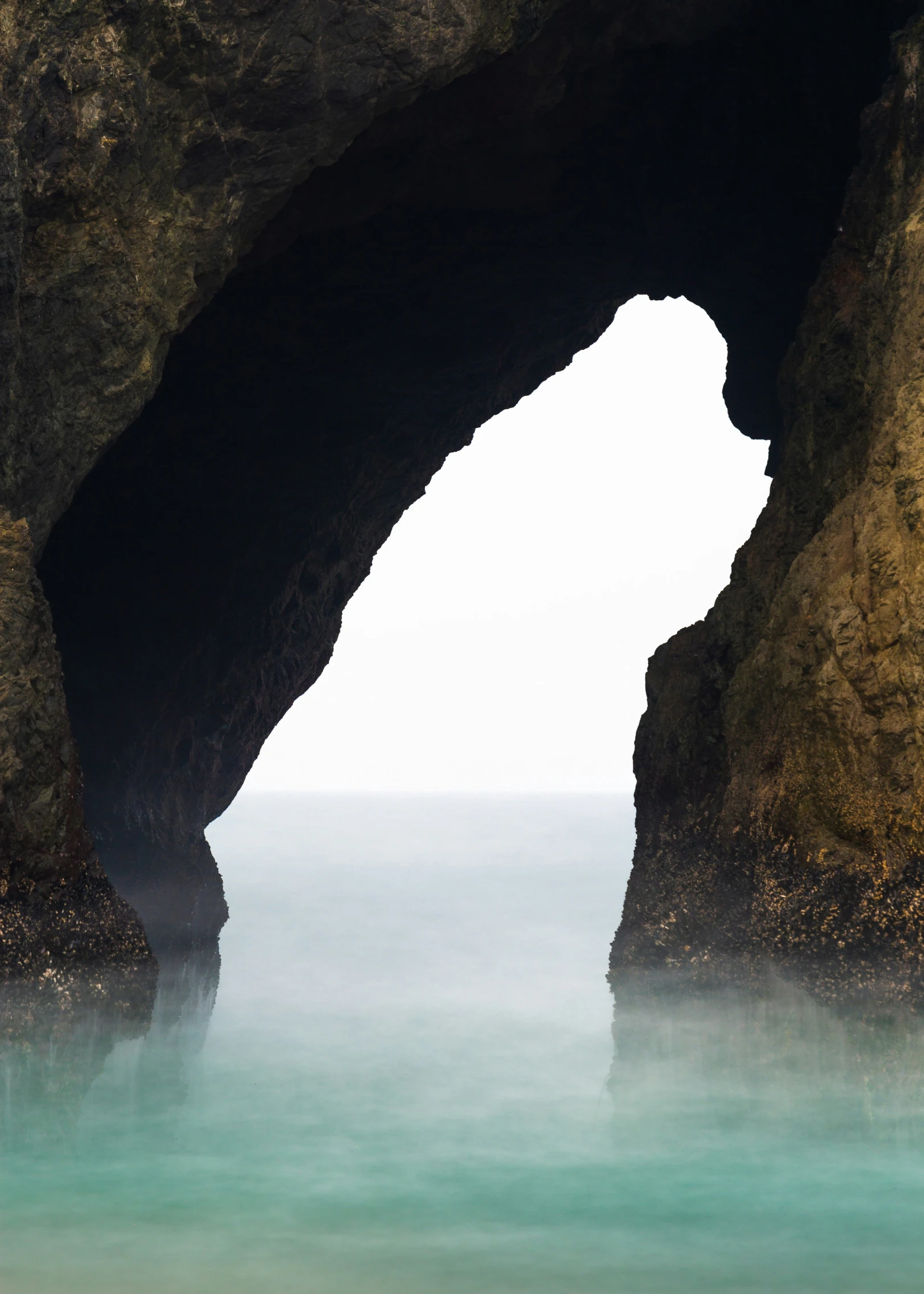 an arch in the rock on the beach