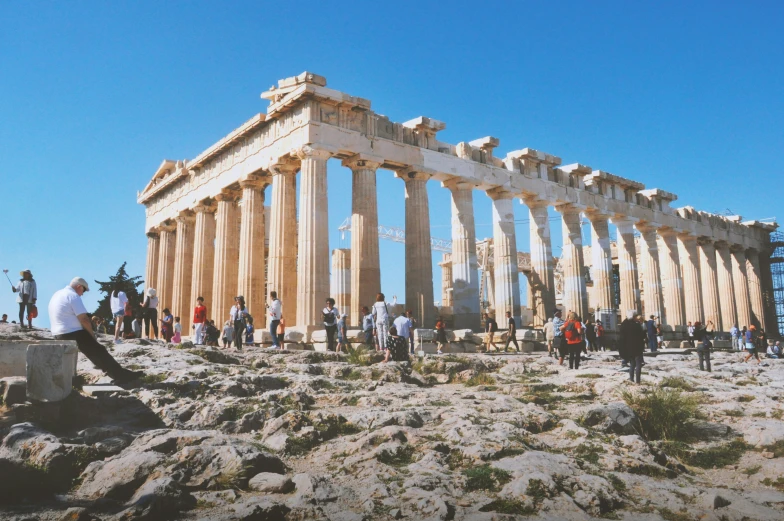 a bunch of people are standing by some big pillars