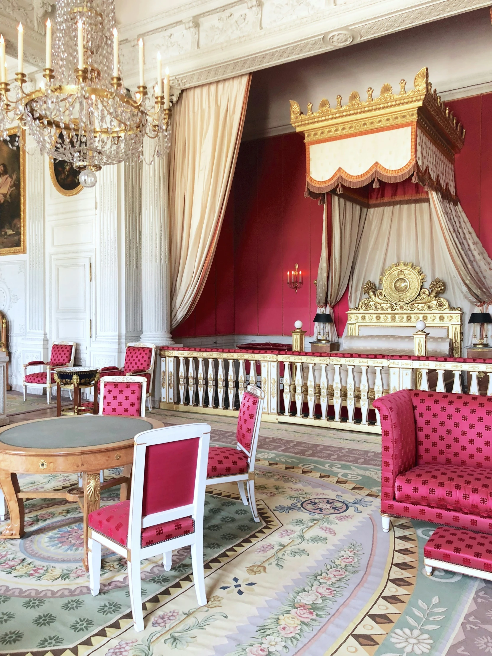 pink chairs and tables in front of a stage in a room