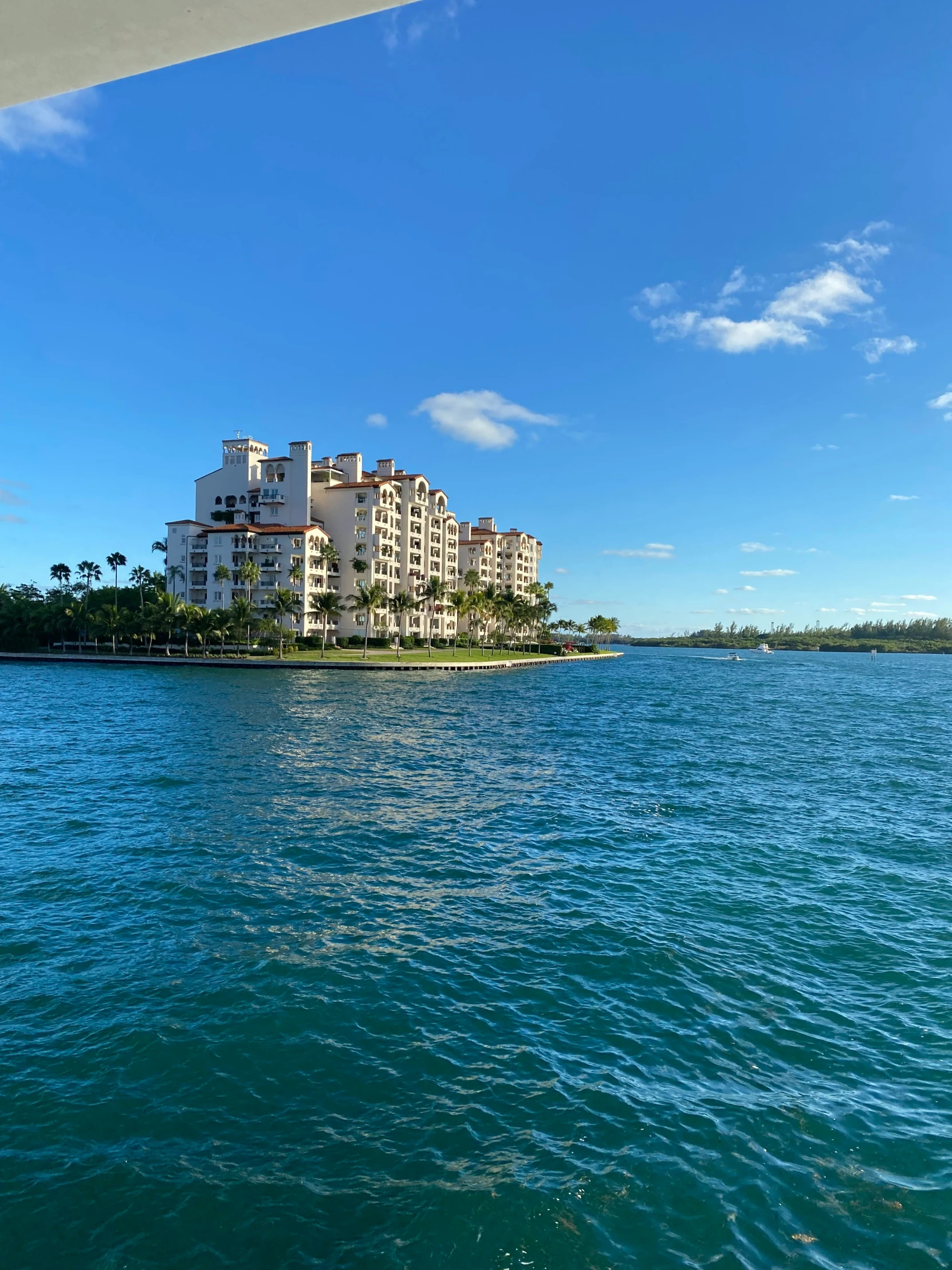 a boat sails past a resort on a island in the ocean