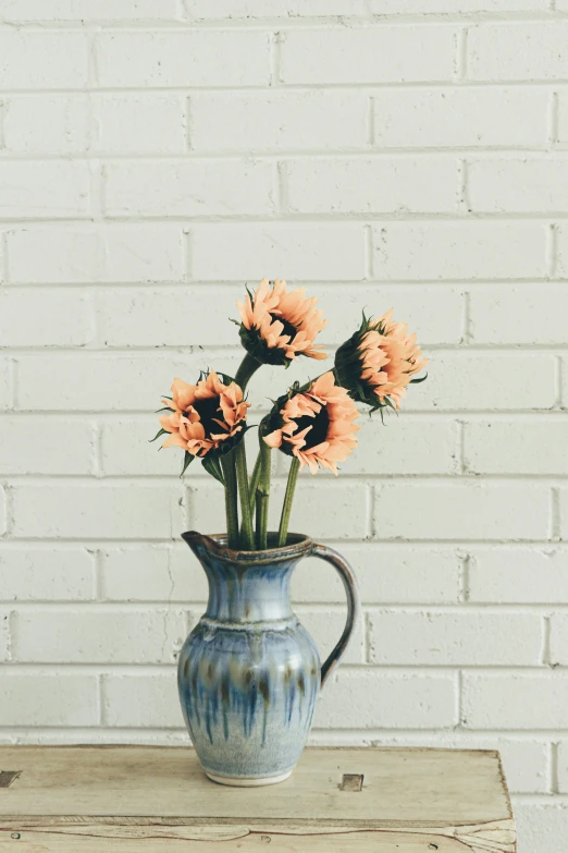 a blue vase filled with flowers on top of a wooden table