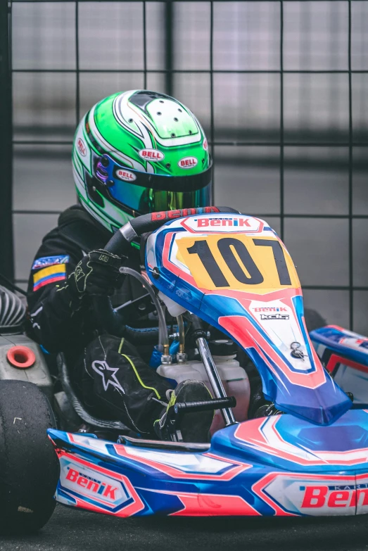 a boy in go kart racing gear on track