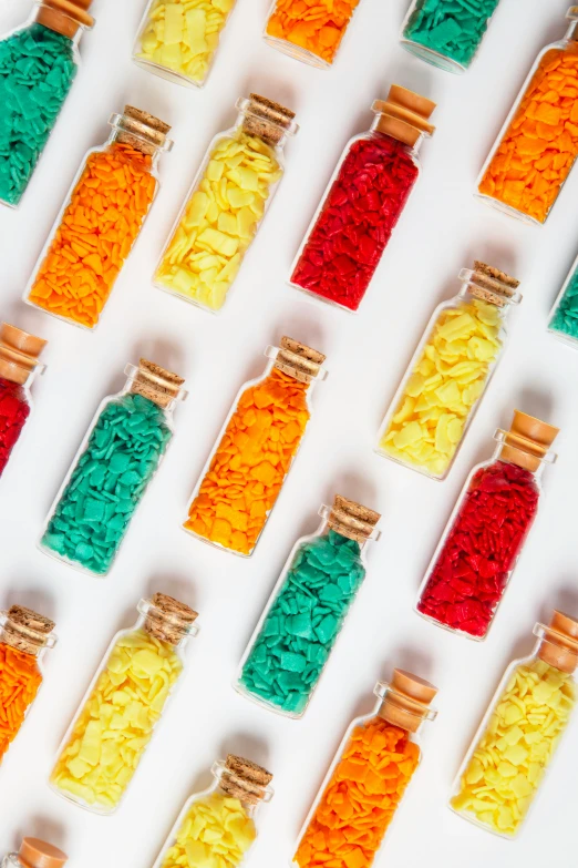 many different colored pieces of plastic sitting in bottles