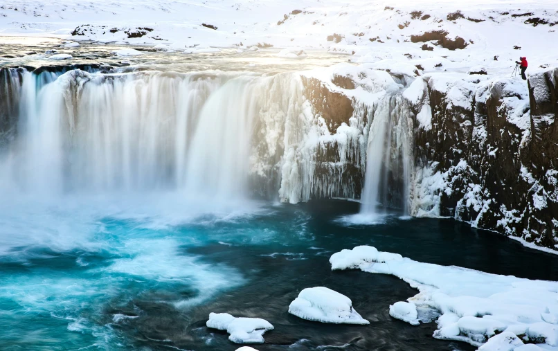 a waterfall in iceland is seen with snow