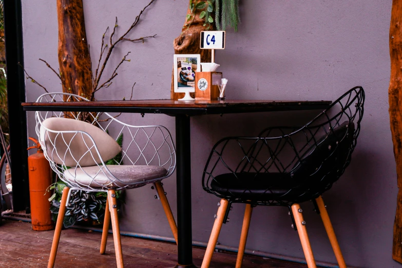 two chairs sit at a table with purple walls and windows