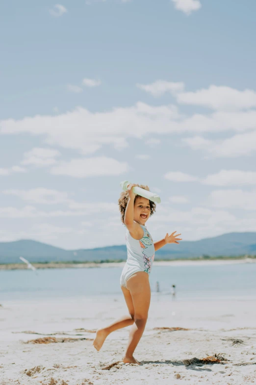 a girl runs on the beach and smiles