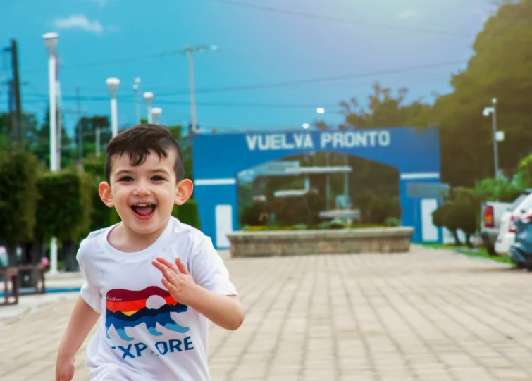 a smiling boy in white shirt standing on the road