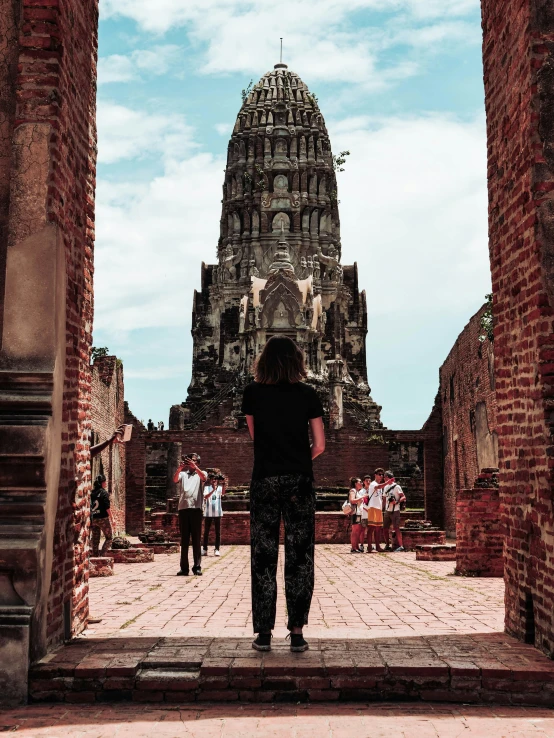 a woman standing in front of some old buildings