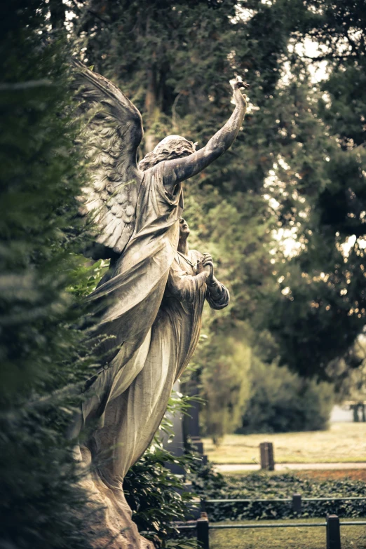 there is a statue with an angel holding an arrow