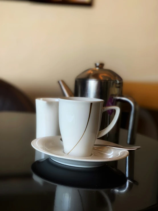 two cups and saucer sitting on a table