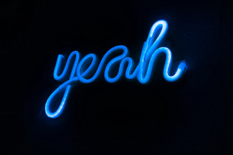 a neon sign that reads yeah in cursive writing
