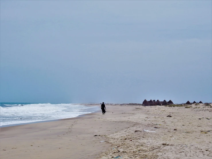 a person is walking on the sand at the beach