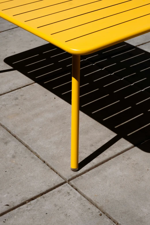 a yellow table is shown on the concrete