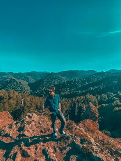 a man standing on top of a red rock