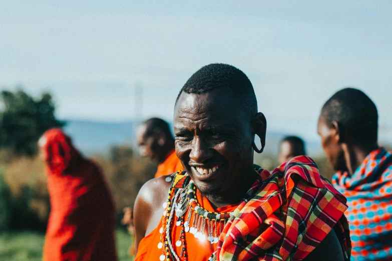 group of ethnic people walking across a grass field