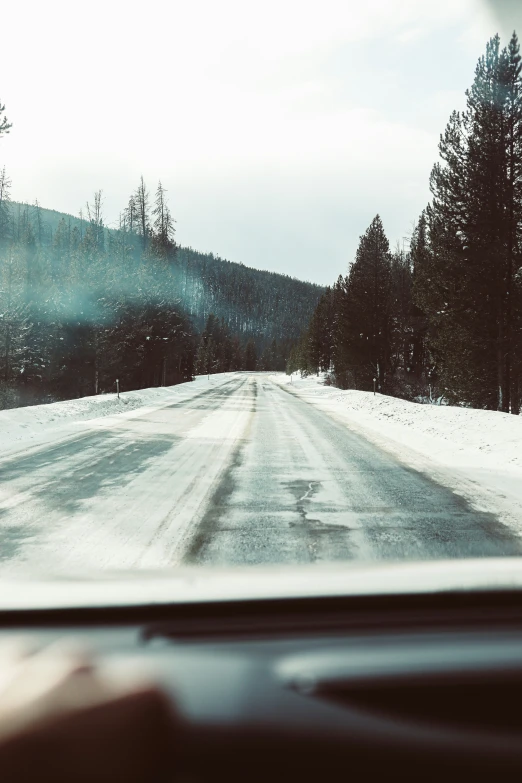 this is a snowy road going through the mountains