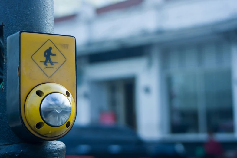 yellow and black safety warning sign with a blue pole