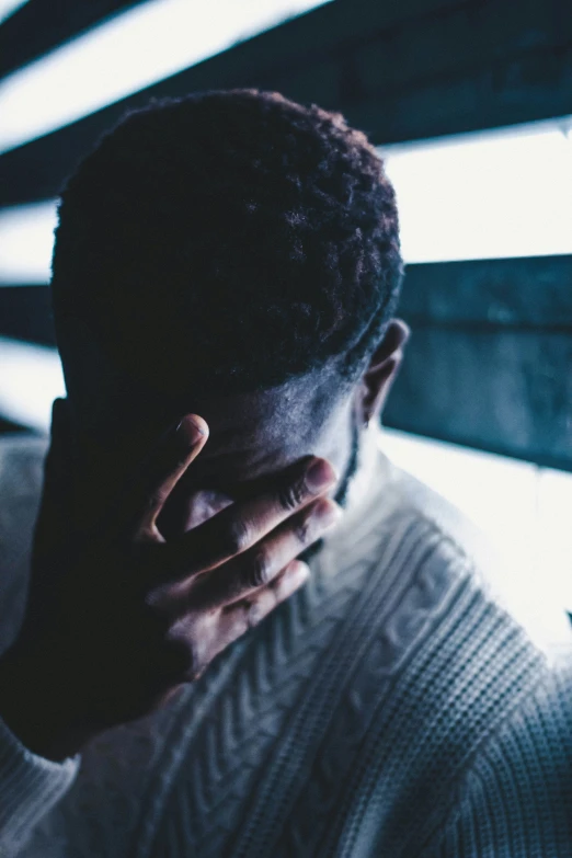 a person standing with their face obscured by a sweater