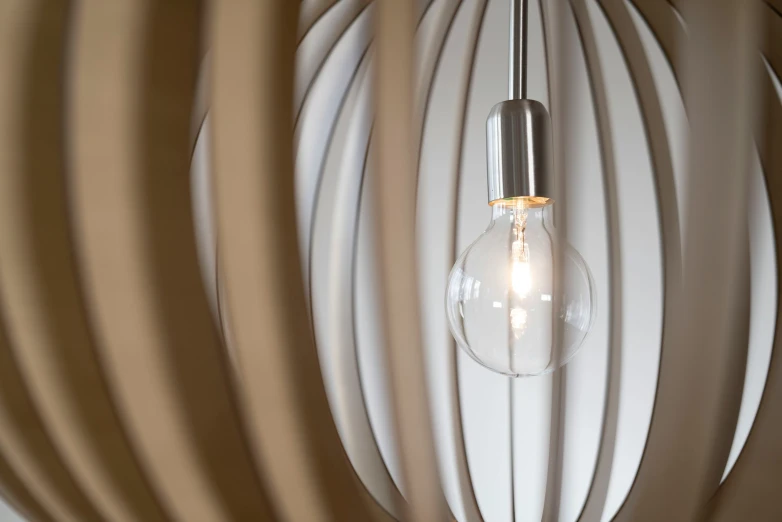 an artistic light bulb on a wall made of wavy white paper