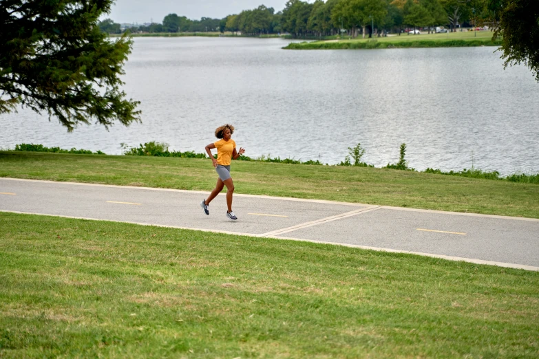 a person jogging along a road by the water