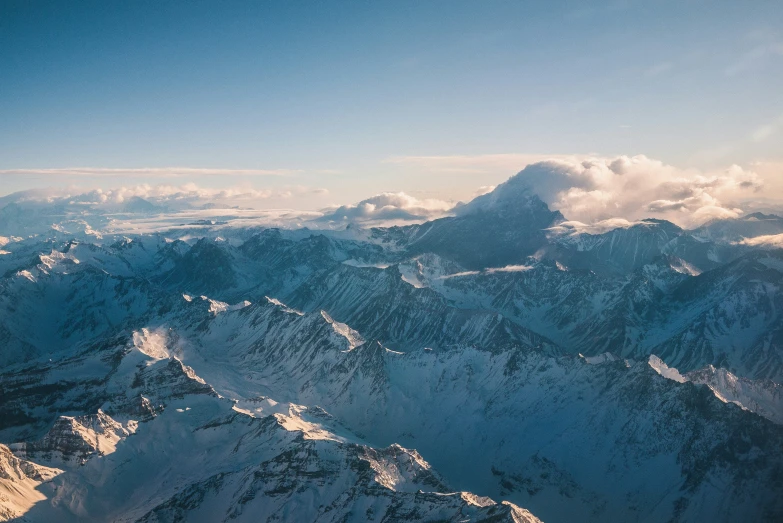 snowy mountain tops at the edge of a blue sky