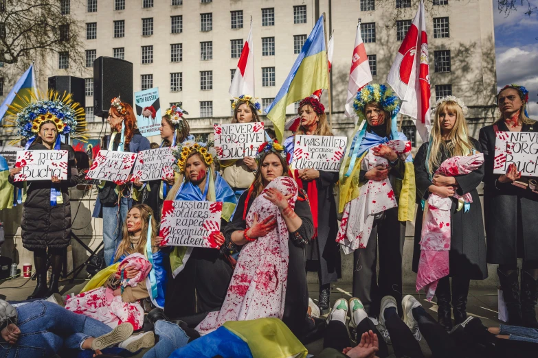 women and children are holding protest signs on a city street