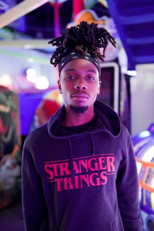 a man with dreadlocks wearing a purple sweatshirt