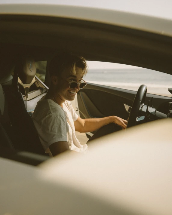 a man sitting in a white car with a steering wheel