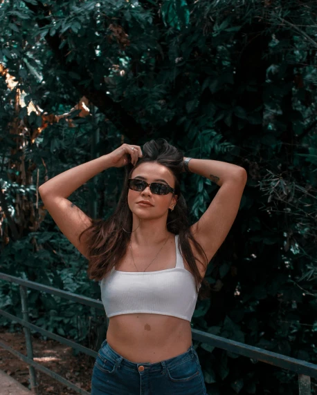 woman with dark sunglasses and cropped top posing