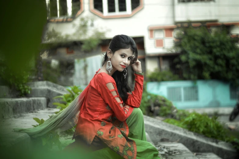 a beautiful woman sitting down next to a building